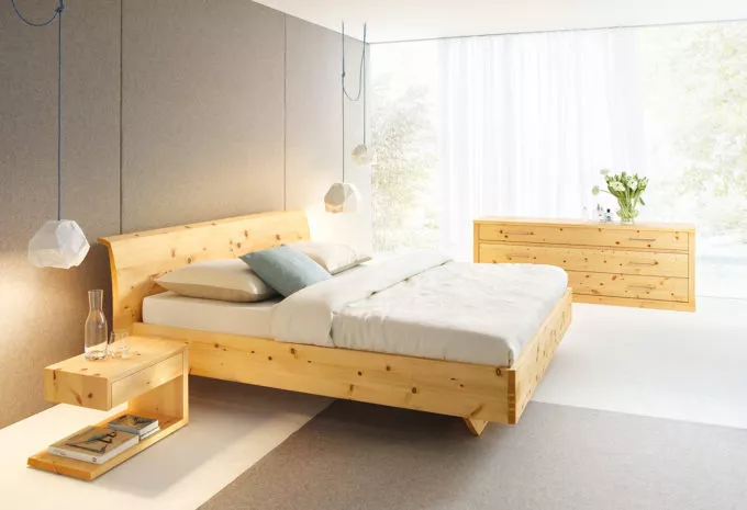 Holzbett in hellem Schlafzimmer